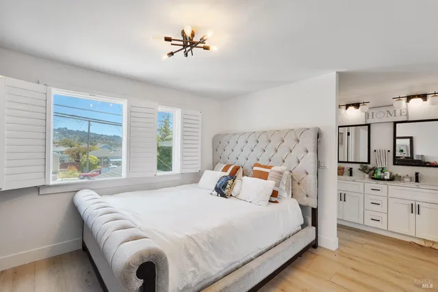 a bedroom with a large bed and a chandelier