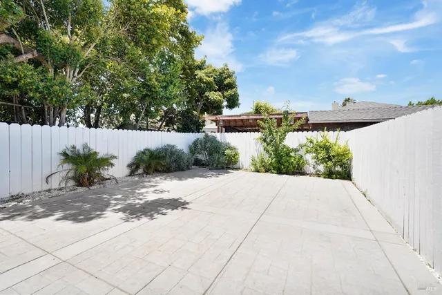 a view of a dry yard with wooden fence