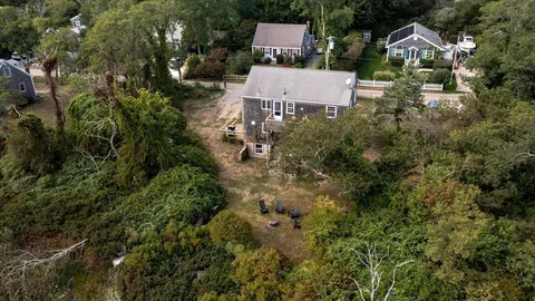 an aerial view of residential house with outdoor space and trees all around