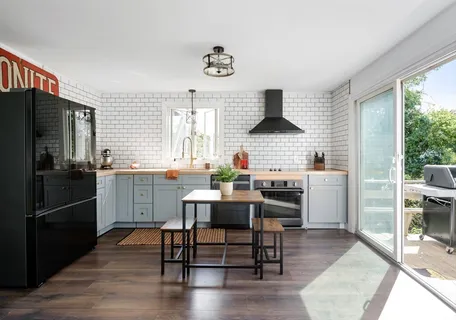 a kitchen with stainless steel appliances kitchen island granite countertop a dining table and chairs