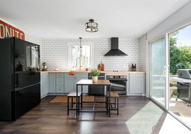 a kitchen with stainless steel appliances kitchen island granite countertop a dining table and chairs