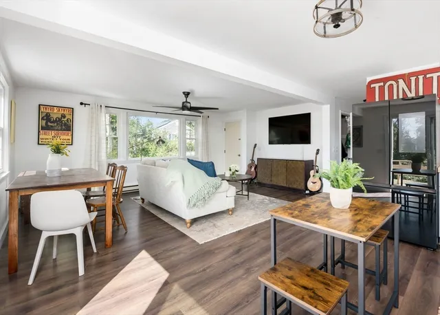 a living room with furniture a flat screen tv and a large window