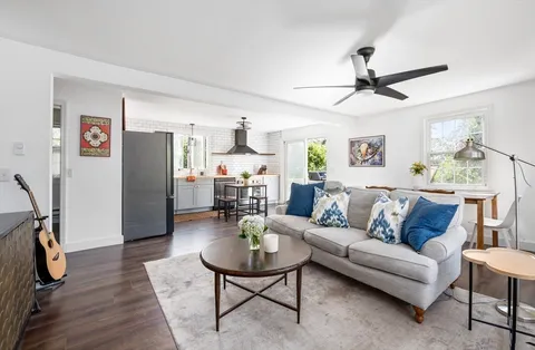 a living room with furniture a wooden floor and a window