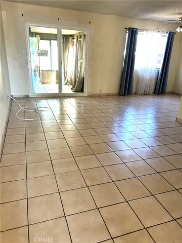 a view of a livingroom with an empty space and a window