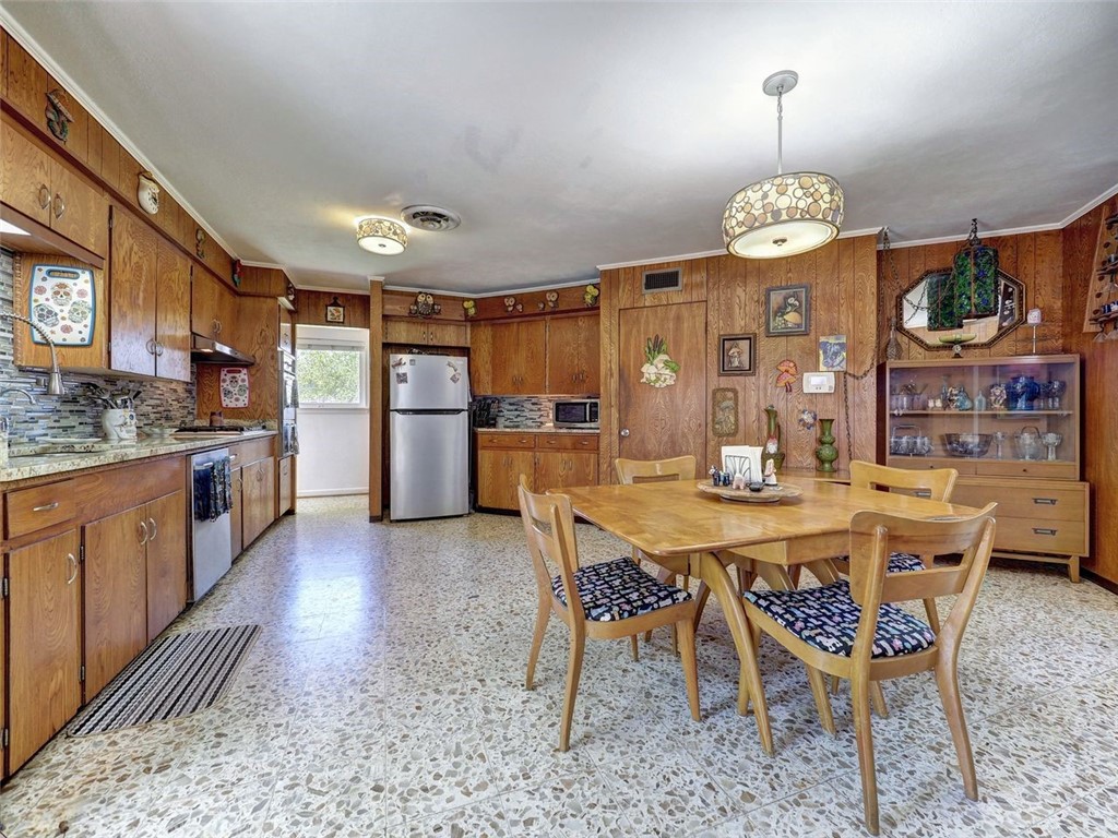 202 Sunset Ingleside, TX 78362 - Photo 4 of 40 a kitchen with stainless steel appliances kitchen island granite countertop a table chairs and a refrigerator
