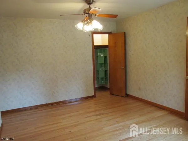 a view of an empty room with a chandelier fan