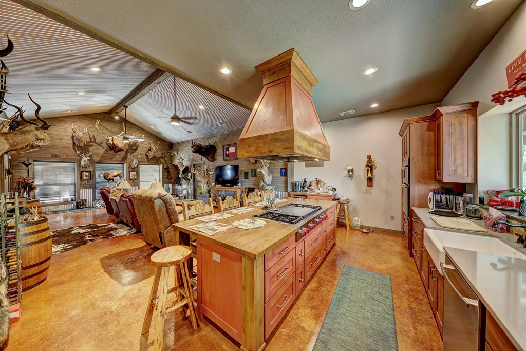 820 Bobby Shelton Ranch Road Northwest Mountain Home, TX 78058 - Photo 15 of 85 a kitchen with stainless steel appliances kitchen island granite countertop a sink and cabinets