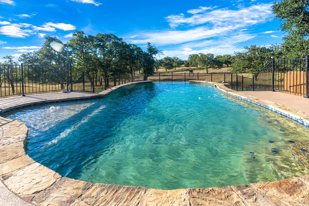 820 Bobby Shelton Ranch Road Northwest Mountain Home, TX 78058 - Photo 21 of 85 a view of a swimming pool with a patio
