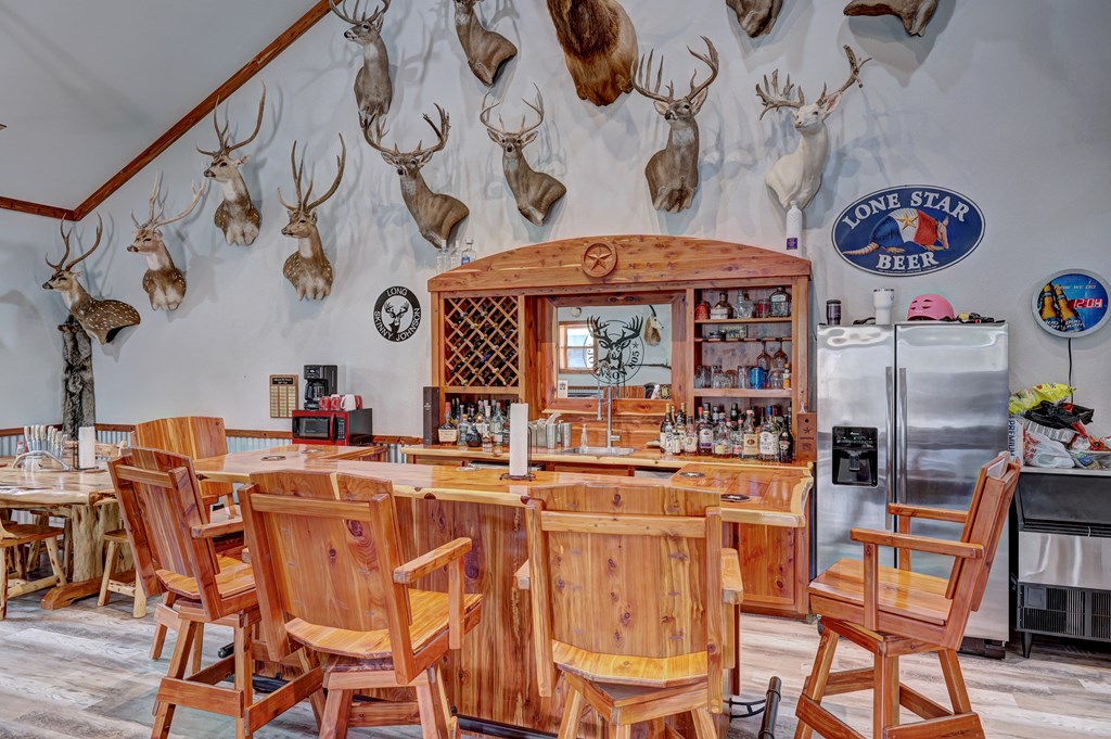 820 Bobby Shelton Ranch Road Northwest Mountain Home, TX 78058 - Photo 25 of 85 a dining hall with stainless steel appliances a dining table and chairs with wooden floor