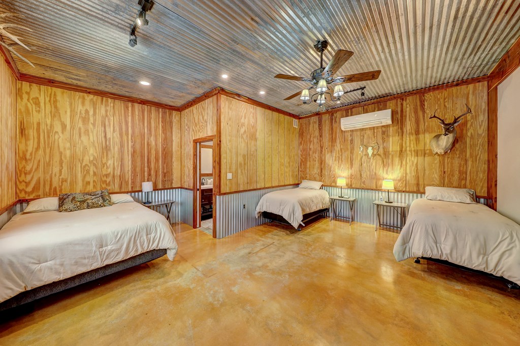 820 Bobby Shelton Ranch Road Northwest Mountain Home, TX 78058 - Photo 33 of 85 a bedroom with two beds and a chandelier