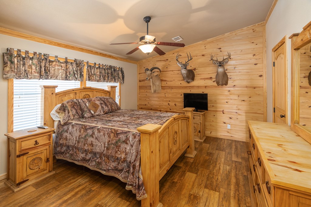 820 Bobby Shelton Ranch Road Northwest Mountain Home, TX 78058 - Photo 42 of 85 a spacious bedroom with a bed and wooden floor