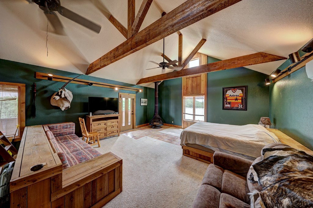 820 Bobby Shelton Ranch Road Northwest Mountain Home, TX 78058 - Photo 51 of 85 a bedroom with furniture and flat screen tv