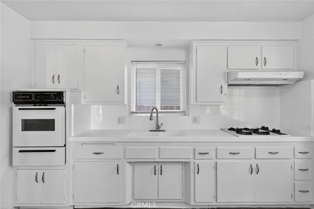 a kitchen with white cabinets and a stove