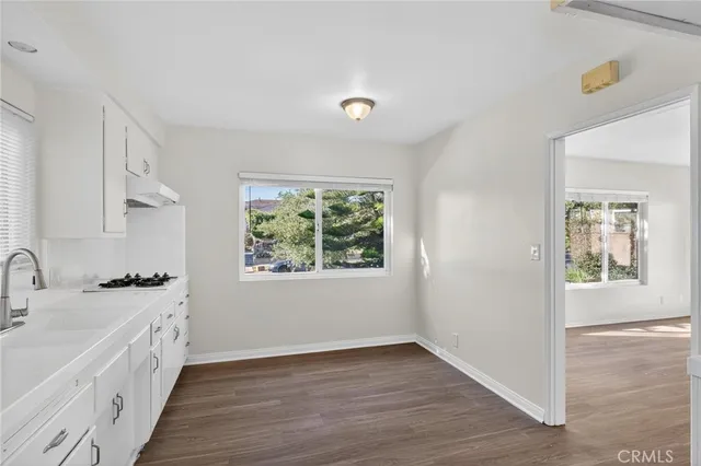 a view of a kitchen with a sink window and wooden floor