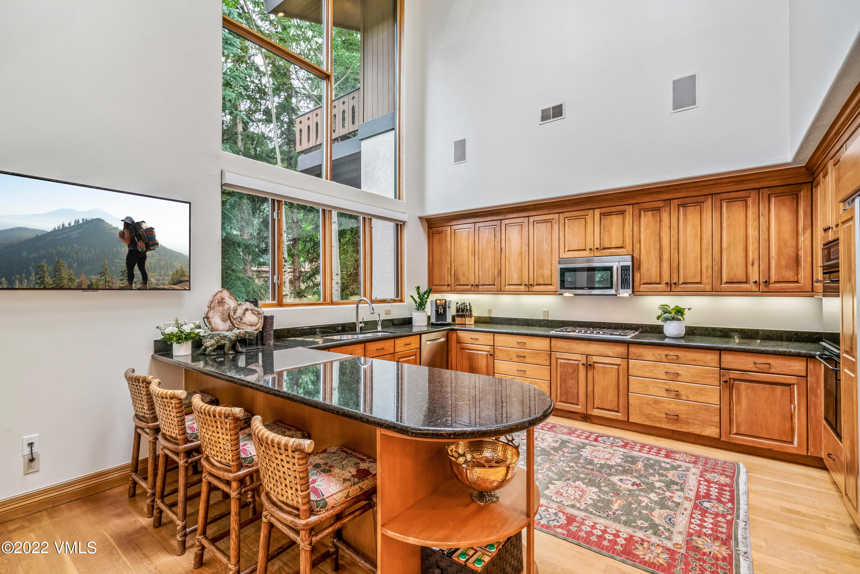 355 Forest Road, Unit B Vail, CO 81657 - Photo 13 of 36 a kitchen with stainless steel appliances granite countertop a sink and a large window
