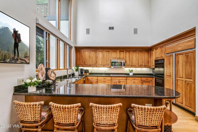 a kitchen with stainless steel appliances granite countertop a stove a sink and a refrigerator