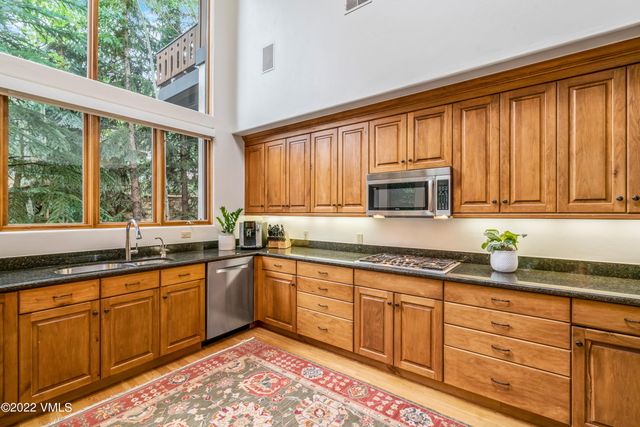 a kitchen with granite countertop wooden cabinets a sink and a window