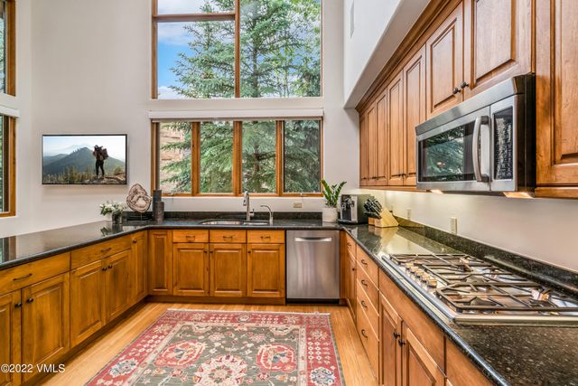 a kitchen with stainless steel appliances granite countertop a stove a sink and a microwave