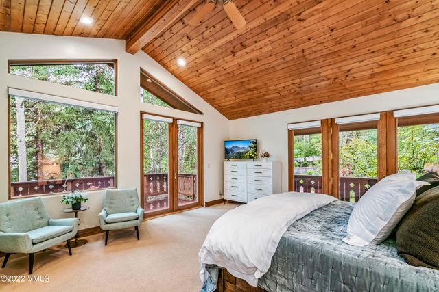 a bed sitting in a spacious bedroom next to a window