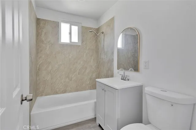 an empty room with wooden floor cabinet and windows