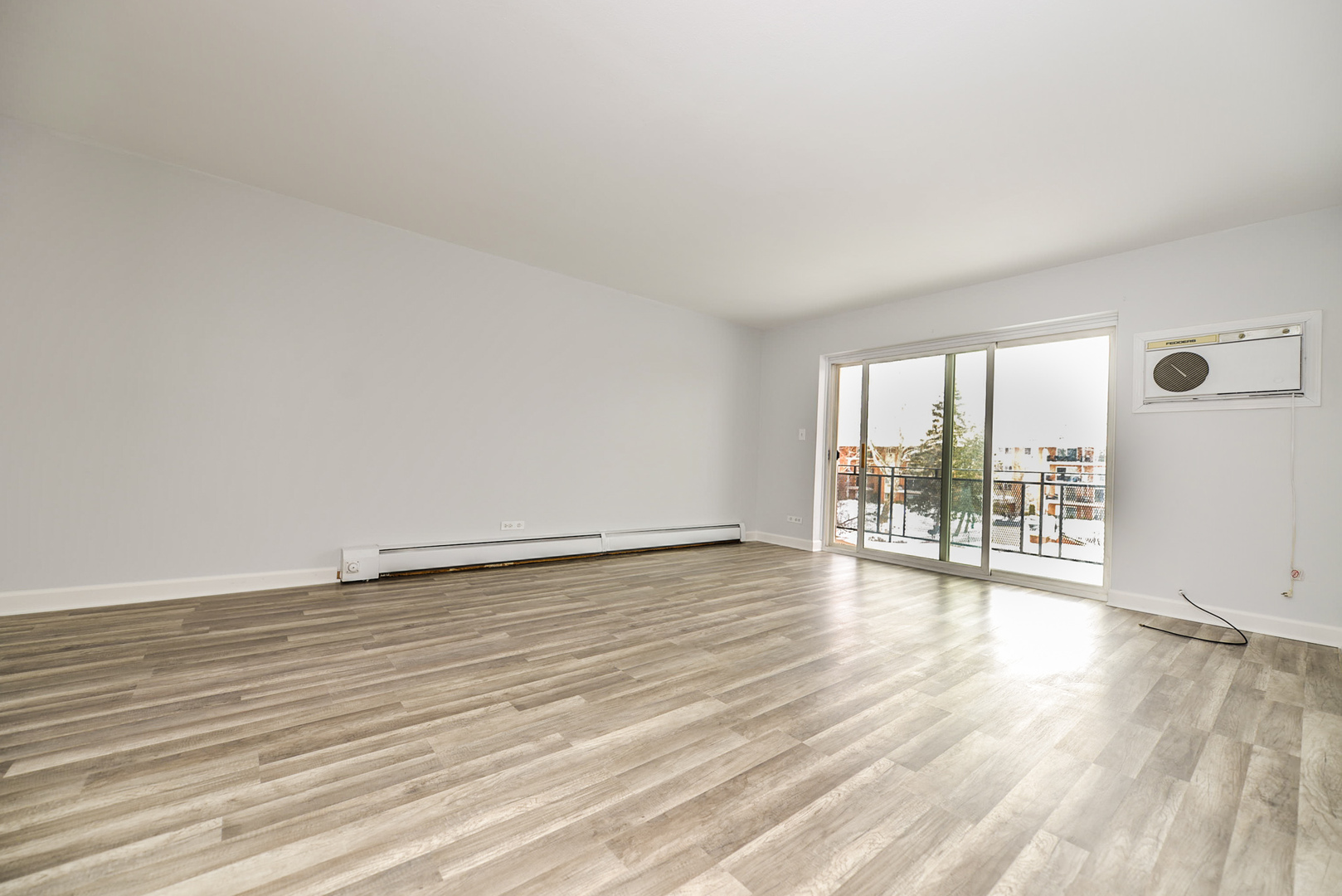 2234 South Goebbert Road, Unit 320 Arlington Heights, IL 60005 - Photo 13 of 37 a view of an empty room with wooden floor and a window