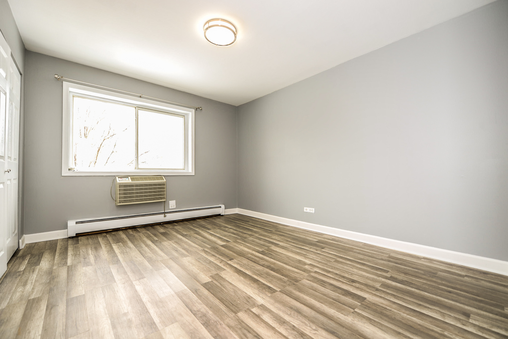 2234 South Goebbert Road, Unit 320 Arlington Heights, IL 60005 - Photo 20 of 37 an empty room with wooden floor and windows