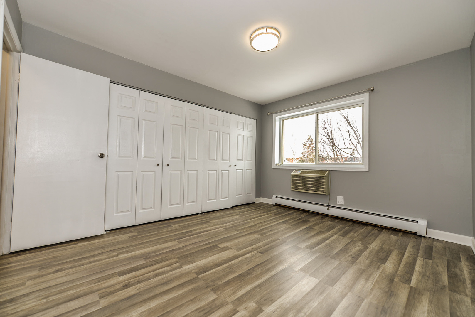 2234 South Goebbert Road, Unit 320 Arlington Heights, IL 60005 - Photo 21 of 37 an empty room with wooden floor and windows