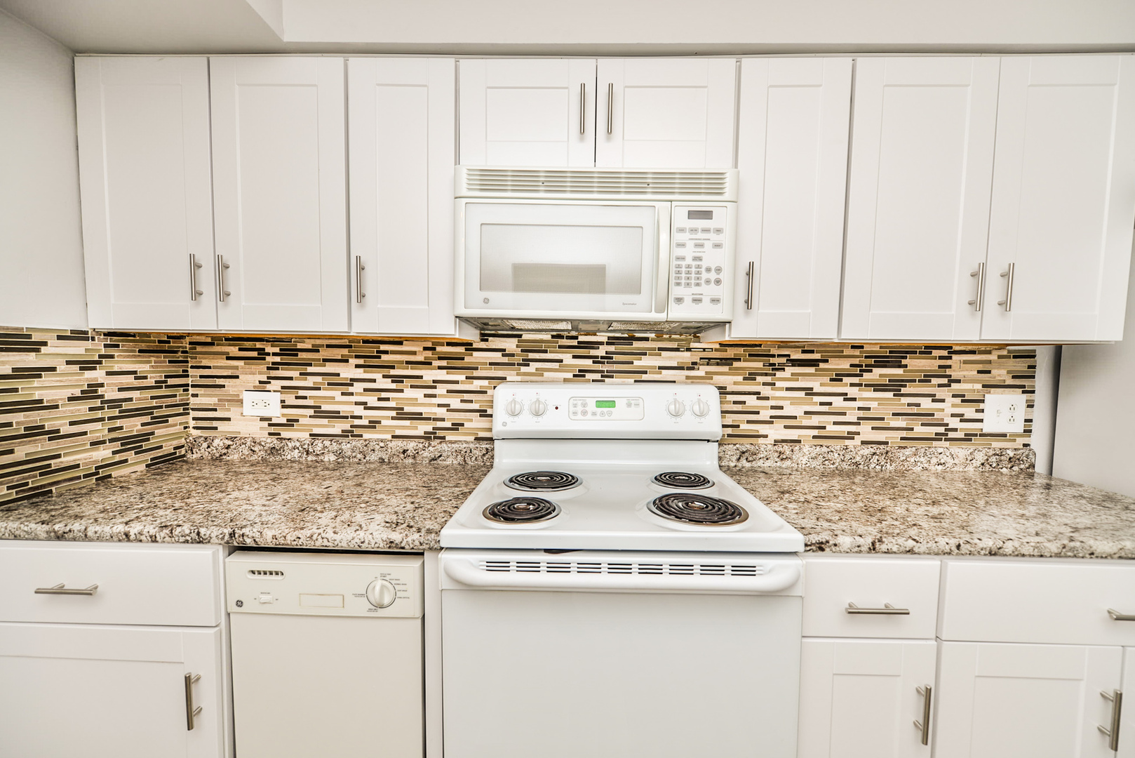 2234 South Goebbert Road, Unit 320 Arlington Heights, IL 60005 - Photo 3 of 37 a kitchen with granite countertop white cabinets and a stove