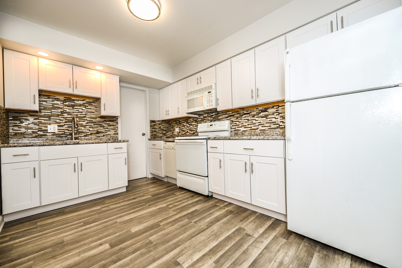 2234 South Goebbert Road, Unit 320 Arlington Heights, IL 60005 - Photo 6 of 37 a kitchen with white cabinets and white appliances