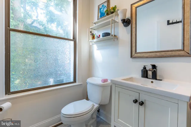a bathroom with a sink a toilet and a mirror