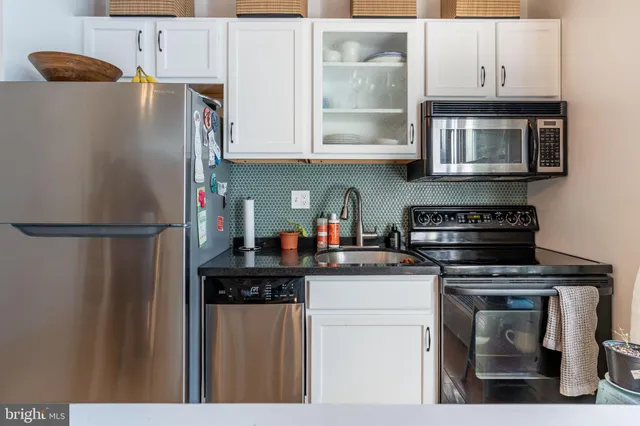 a kitchen with stainless steel appliances granite countertop a refrigerator sink and stove