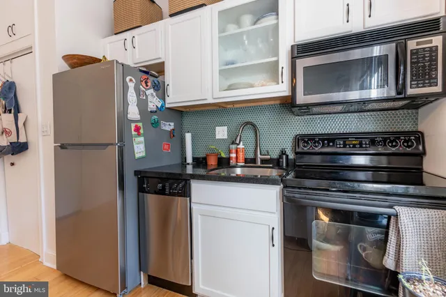 a kitchen with stainless steel appliances granite countertop a refrigerator and a stove top oven