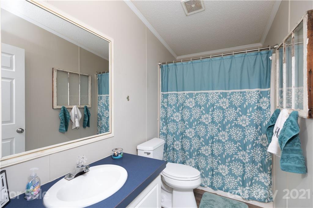 854 West Rambo Road Rock Hill, SC 29730 - Photo 23 of 27 a bathroom with a granite countertop sink a toilet a mirror and shower curtain