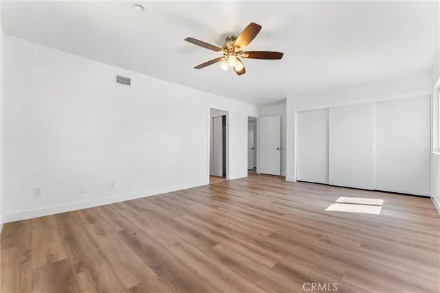 an empty room with wooden floor and window