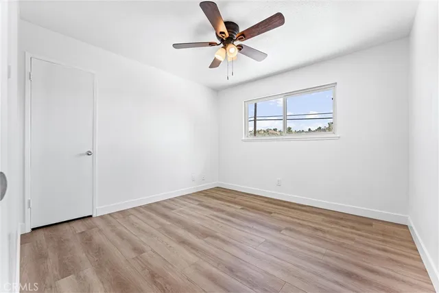 a view of a room with wooden floor and a ceiling fan