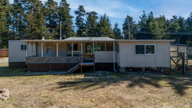 a view of a house with backyard and trees