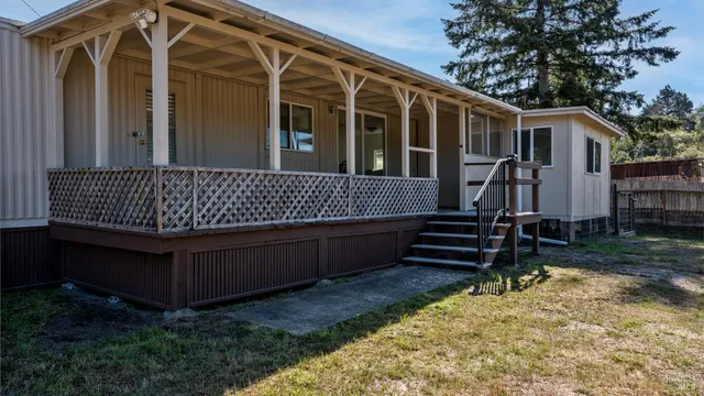 a view of a house with backyard and wooden fence