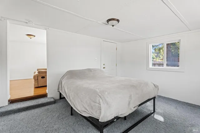 a bed sitting in a bedroom next to a window