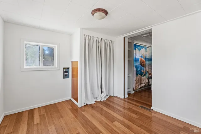 an empty room with wooden floor and a window