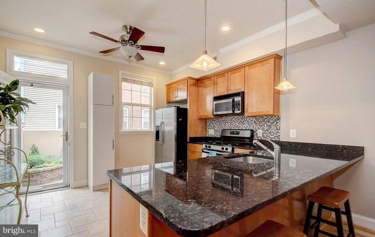 a kitchen with stainless steel appliances granite countertop a sink a stove and a refrigerator