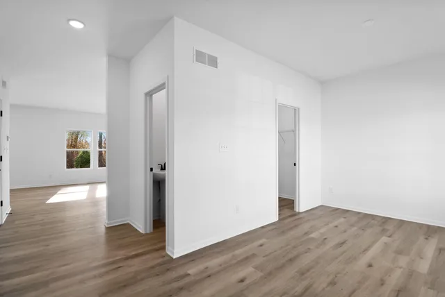 a view of empty room with wooden floor