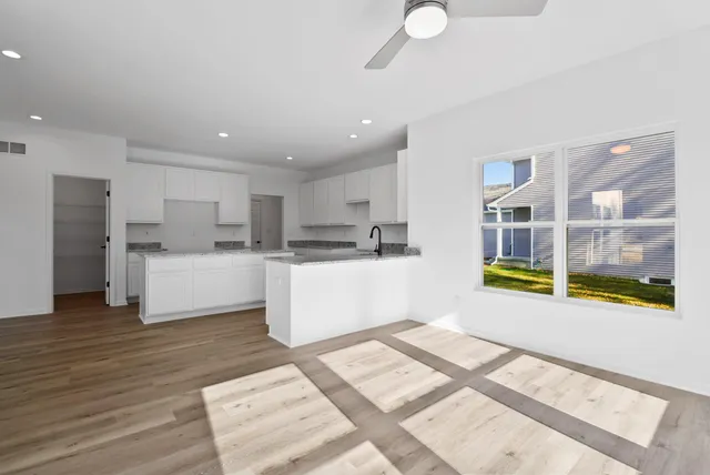 a living room with stainless steel appliances kitchen island granite countertop a refrigerator and a sink