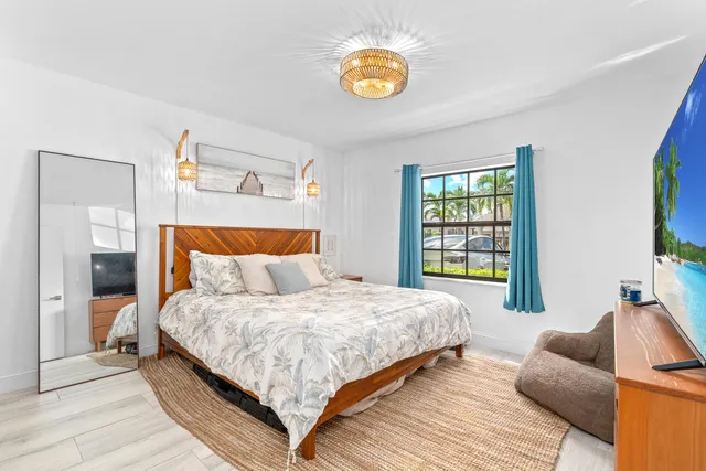 a bedroom with a bed and painting on the wall