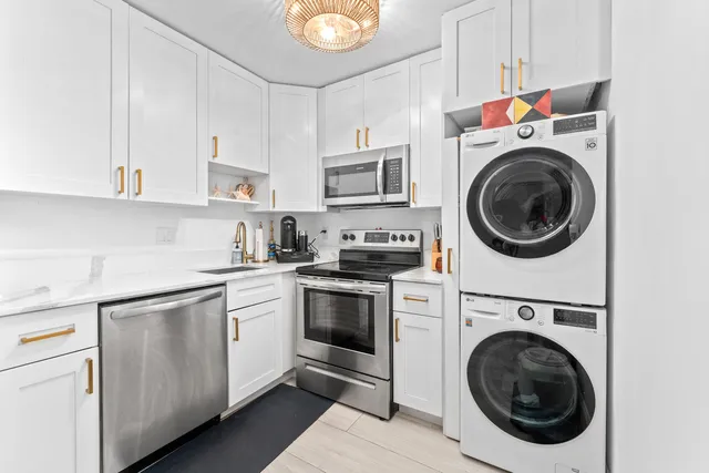 a kitchen with cabinets a washer and dryer