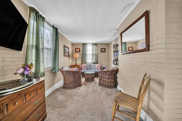 a view of a hallway with wooden floor and furniture