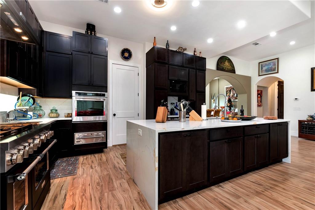 1197 Dee Kennedy Road Auburn, GA 30011 - Photo 12 of 78 a kitchen with stainless steel appliances kitchen island granite countertop a refrigerator a sink and wooden cabinets