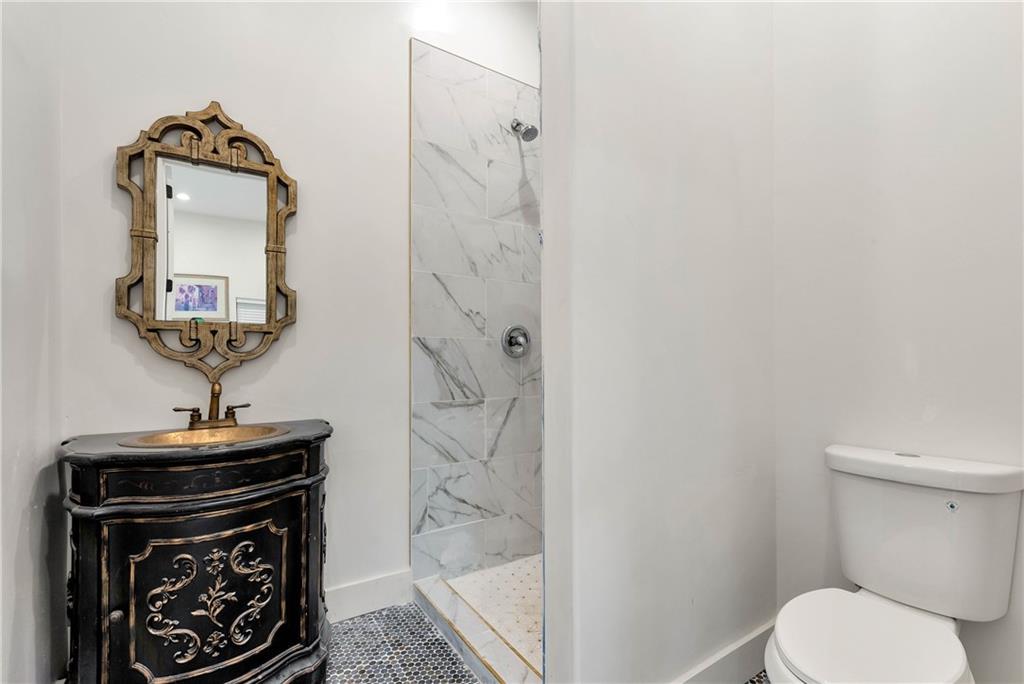 1197 Dee Kennedy Road Auburn, GA 30011 - Photo 37 of 78 a bathroom with a toilet a sink and mirror