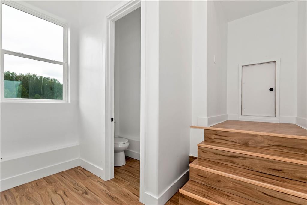 1197 Dee Kennedy Road Auburn, GA 30011 - Photo 53 of 78 a view of a hallway with wooden floor and a bathroom