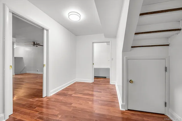 a view of a hallway with wooden floor and closet