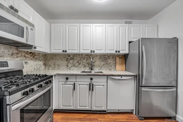 a kitchen with stainless steel appliances granite countertop a stove a refrigerator and a granite counter tops